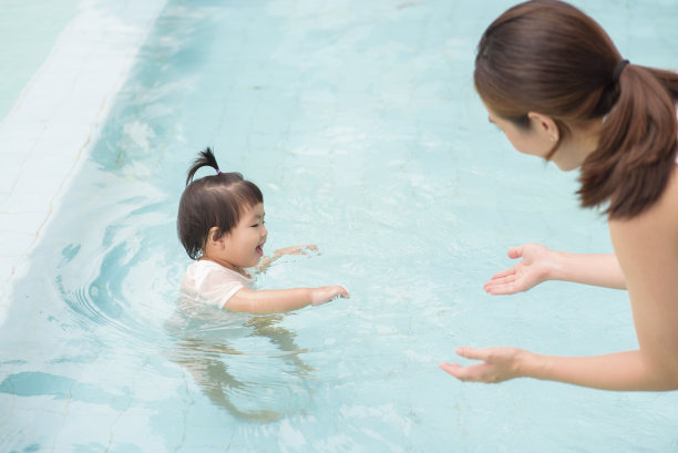 妈妈训练孩子们在游泳池游泳