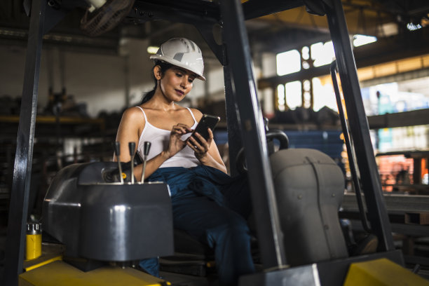 女工在工厂使用手机