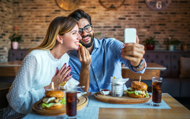 快乐夫妻坐在咖啡店用智能手机