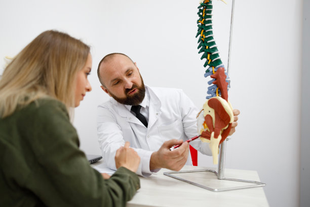 物理治疗师对患者解释脊柱模型