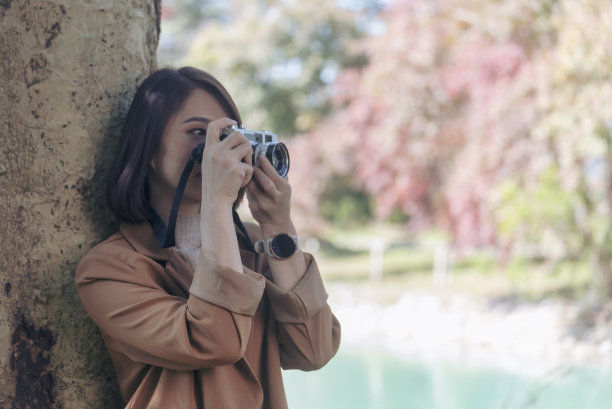 年轻的亚洲摄影师手持复古胶卷相机的肖像。