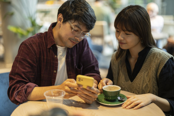快乐夫妻坐在咖啡店用智能手机