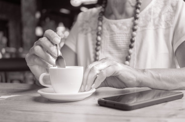 坐在咖啡馆喝咖啡的老年妇女