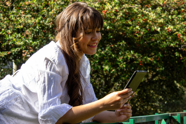 年轻女子在公园使用平板电脑