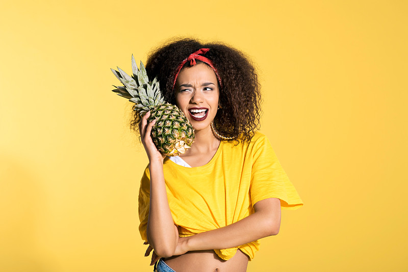 菠萝,青年人,女人,幸福,拿着,彩色背景,黄色背景,水果,影棚拍摄,非裔美国人