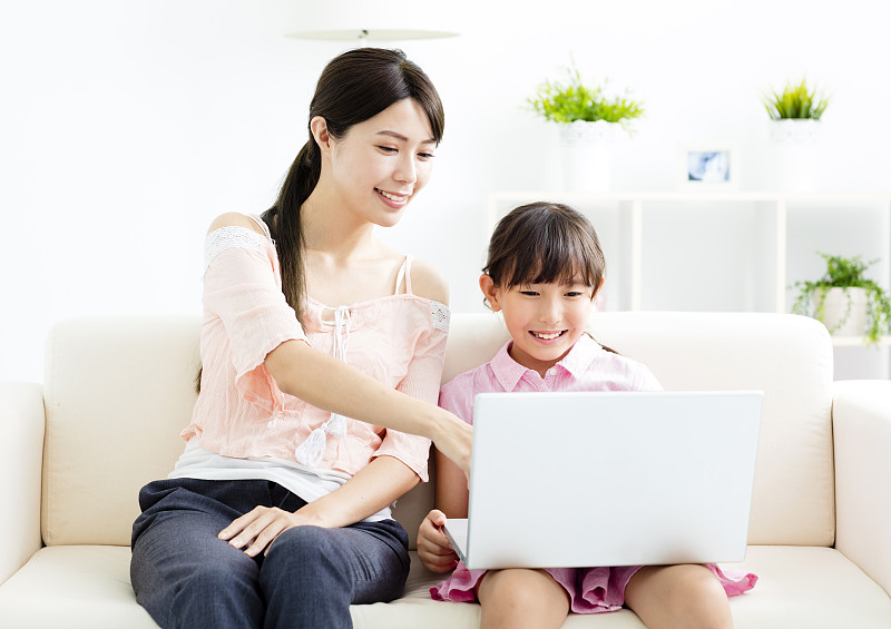 mother,with,,daughter,looking,at,Laptop?,on,sofa