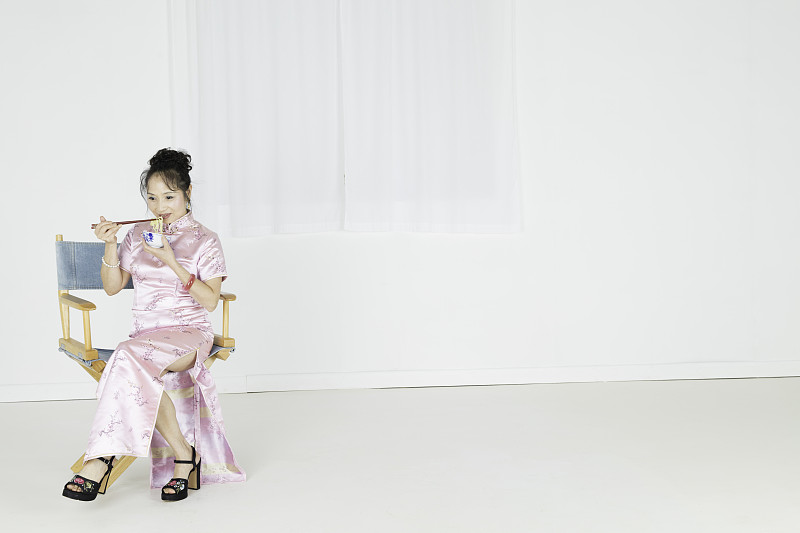 旗袍,粉色,面条,衣服,女人,老板椅,仅一个中老年女人,50到59岁,筷子,窗帘