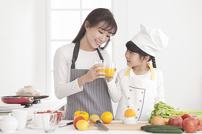 妈妈跟女儿在厨房喝果汁