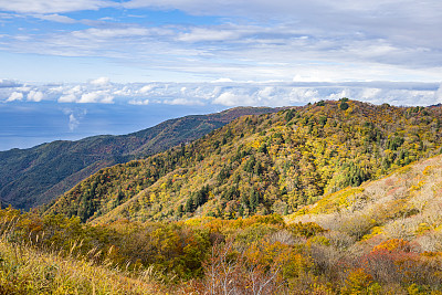 佐渡岛:从日本新泻县佐渡天际线的最高点看，佐渡山和日本海的秋叶景色