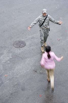 女人伸开双臂向士兵跑去