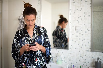 浴室里拿着手机的女人