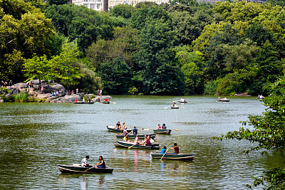美国纽约市曼哈顿中央公园湖中划艇的人们