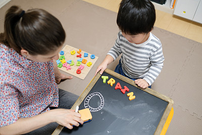 白人妇女用黑板教小孩英语