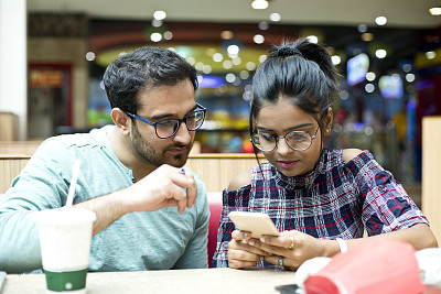 情侣在餐厅使用手机