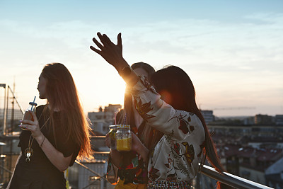 三个年轻女人在外面喝鸡尾酒