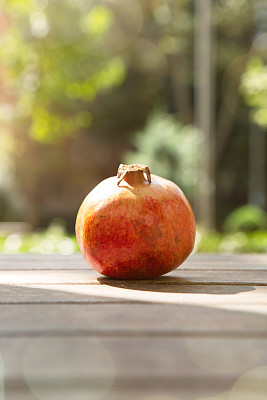 公园木桌上的石榴。水果和蔬菜概念。 公园木桌上的石榴。水果和蔬菜概念。