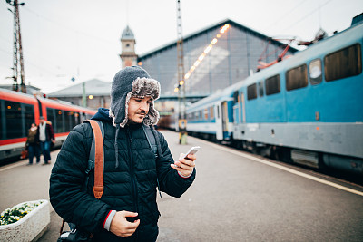 一名男子在火车站使用手机