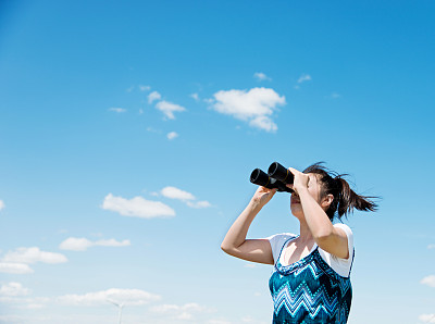 一位妇女用双筒望远镜看天空
