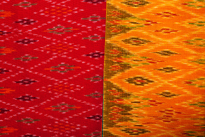 红色和橙色的伊卡特面料在印度尼西亚纺织品市场，乌布，巴厘岛