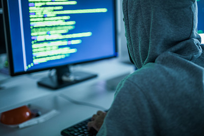电脑黑客在办公室里偷电脑软件。