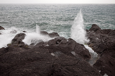 在多岩石的海岸上击碎波浪