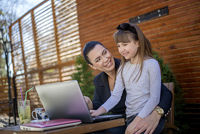 商业妈妈和女儿一起使用现代科技
