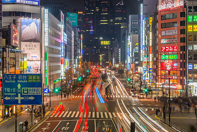 在日本新宿，霓虹闪烁的夜空下，东京的交通飞驰而过