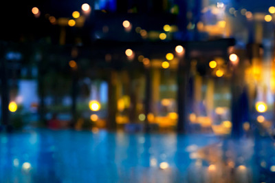 模糊的蓝色游泳池派对灯光在黑暗的夏夜抽象背景