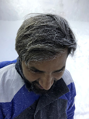 印度男子在法国阿尔卑斯山度假度假滑雪，头发上有高山冰雪，穿着滑雪服，看起来很冷很冷，眉毛和睫毛上有冰，脸上有冰冻的温度，寒冷的冬天天气圣诞节