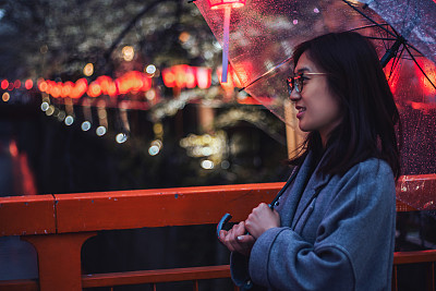 年轻女子在目黑河边欣赏樱花