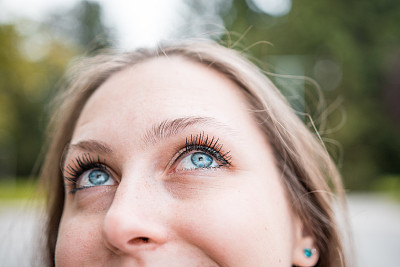 一个年轻漂亮的棕色头发的女人的肖像环顾她的户外