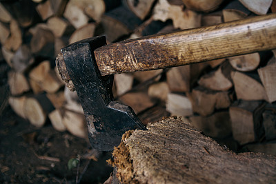 斧头被刀刃刺进了树桩。木柄斧
