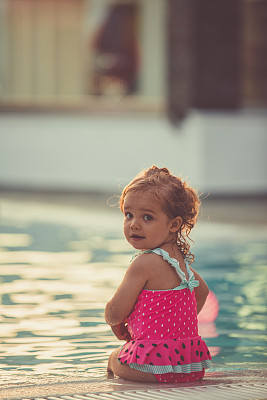 在泳池边微笑的小女孩