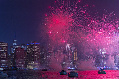 7月4日，人们在曼哈顿市中心前的东河上观看五颜六色的焰火。