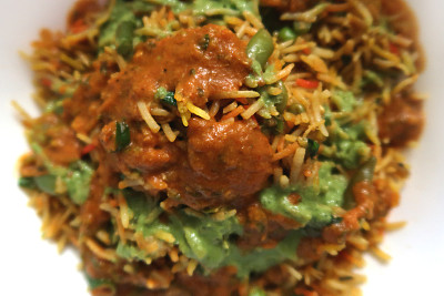 印度新德里外卖餐厅的蔬菜biriyani食谱没有鸡肉的咖喱菜，配上香料、肉汁酱、白肉饭、香菜香草、黑色餐桌、辣椒、法国青豆、绿酸辣酱