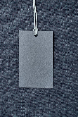蓝色亚麻衣服背景上的空白纸标签
