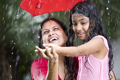 快乐的母亲和女儿在雨中