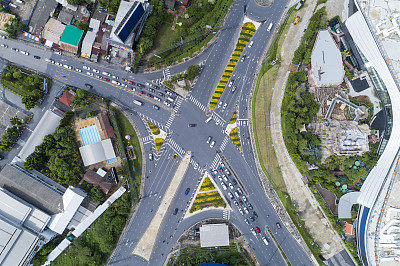 无人机俯视图从上到下的道路交叉口图像为交通背景，汽车交通的许多汽车和标志，标志在道路上
