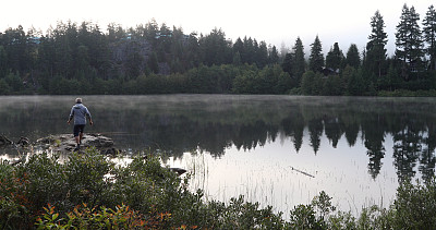 清晨，人们沿着湖边的岩石散步