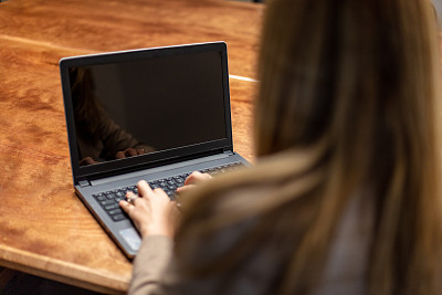 成年女性X一代案例经理办公室设置主任审查文件，使用笔记本电脑的技术交流和站在肖像系列在西科罗拉多州