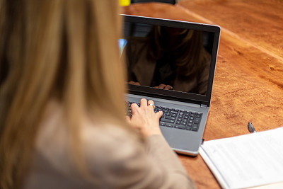 成年女性X一代案例经理办公室设置主任审查文件，使用笔记本电脑的技术交流和站在肖像系列在西科罗拉多州