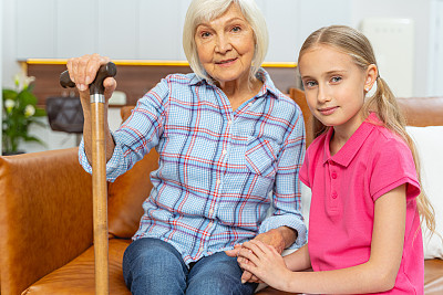 一个拄着拐杖的女人和她的孙女坐在一起