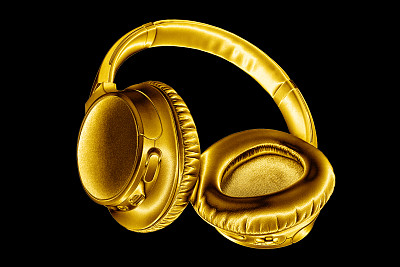 金色闪亮的无线耳机，黑色背景隔离近景，豪华金色金属蓝牙耳机，现代高端wi-fi黄色耳机，音频音乐符号，立体声电子音响标志