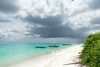 马尔代夫的热带岛屿，绿松石海，椰子树和蓝天。印度洋上的日落