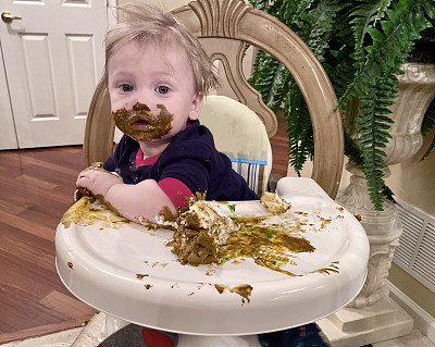 一岁的小男孩在享受他的第一个生日蛋糕