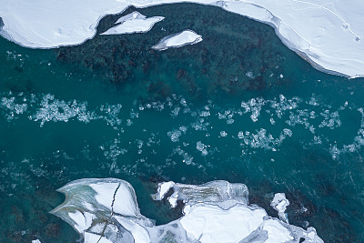 航拍的蓝色和绿色的河流与雪和碎冰在冬季冰漂移在俄罗斯阿尔泰山脉。