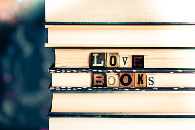 靠近一堆写着“爱的书”的彩色木制字母瓷砖的书