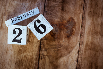 2月26日。2月26日，白色的日历块放在复古的木桌上作为背景。冬天的时间。文本的空白。
