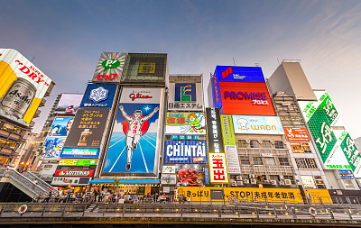 在日本大阪的道顿堀，五颜六色的广告牌照亮了大阪夜市周围的商店和零售店