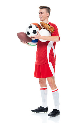 白人少年运动员站着戴着棒球手套，拿着水球和踢足球-运动和使用运动球